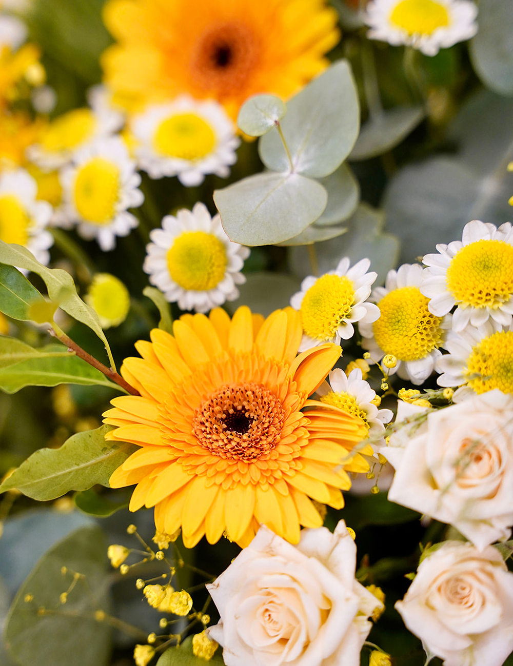 Bouquet de fleurs au style champêtre et vaporeux dans les tons jaunes, blancs et verts.