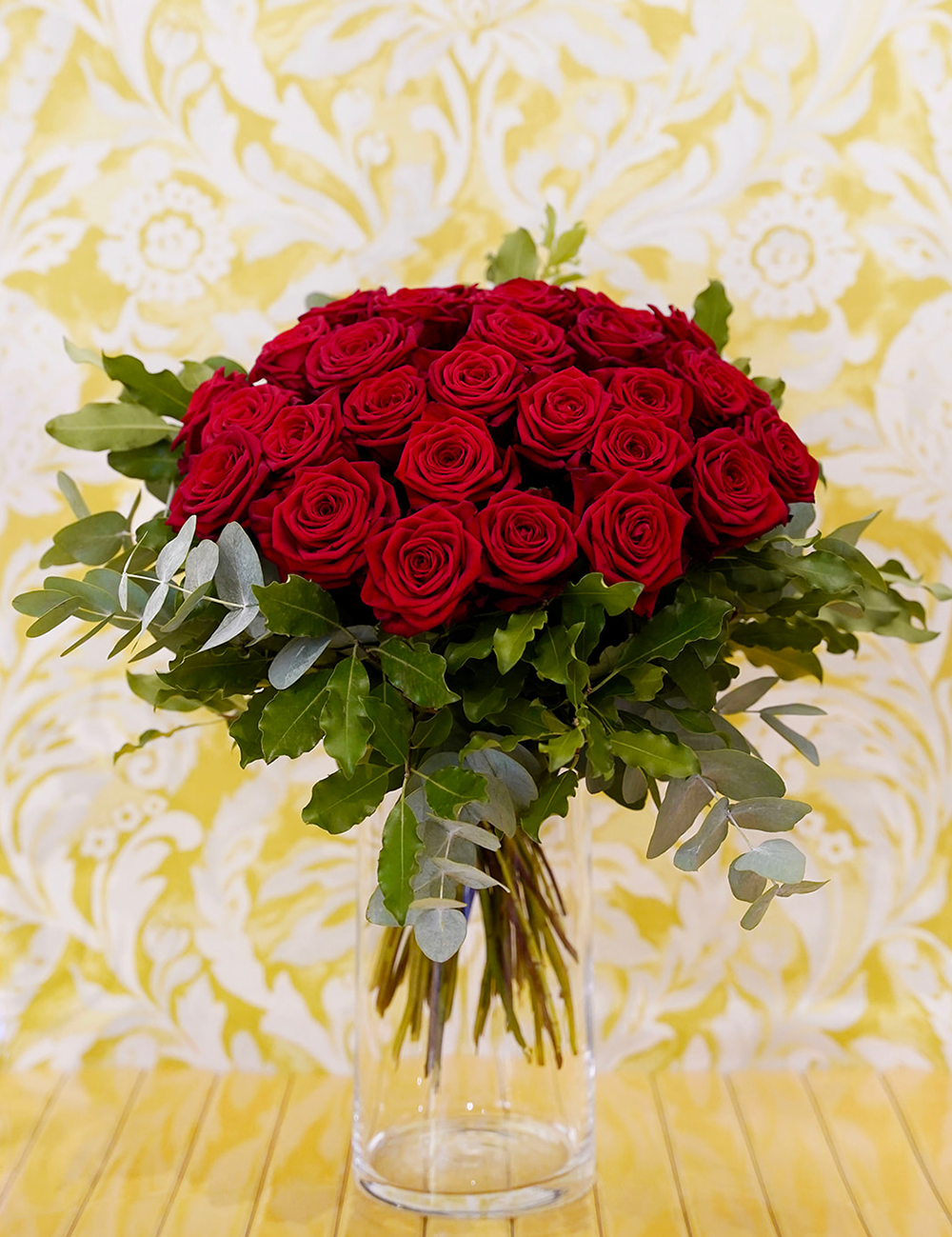Bouquet de roses dans les tons rouges avec des touches de vert.