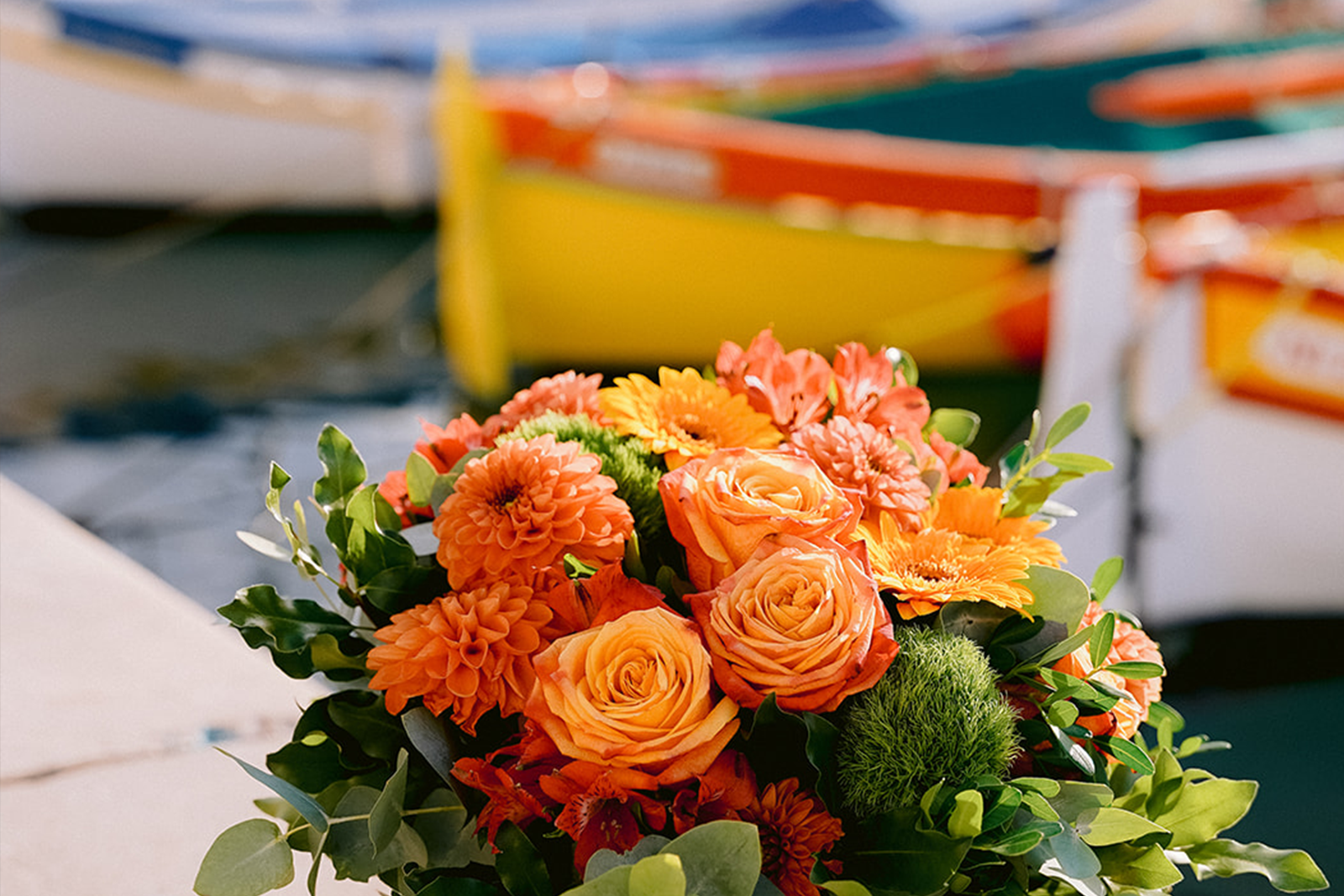Bouquet de fleurs aux tons orangés et verts avec roses, dahlia et gerberas.
Création florale du fleuriste Maison Fiori à Nice.