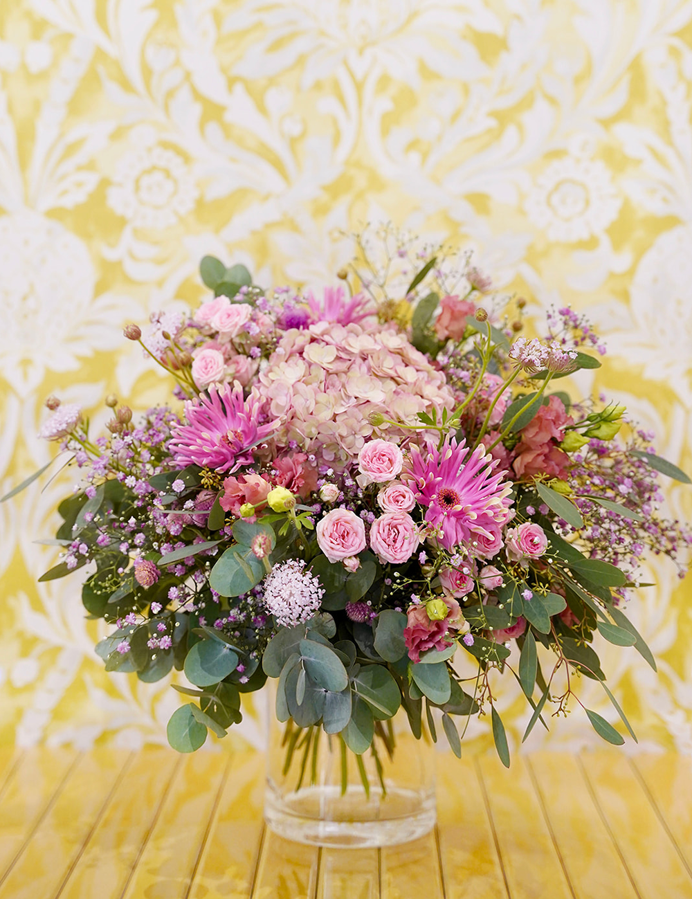 Bouquet de fleurs au style champêtre et vaporeux dans les tons rosés avec des touches de vert.