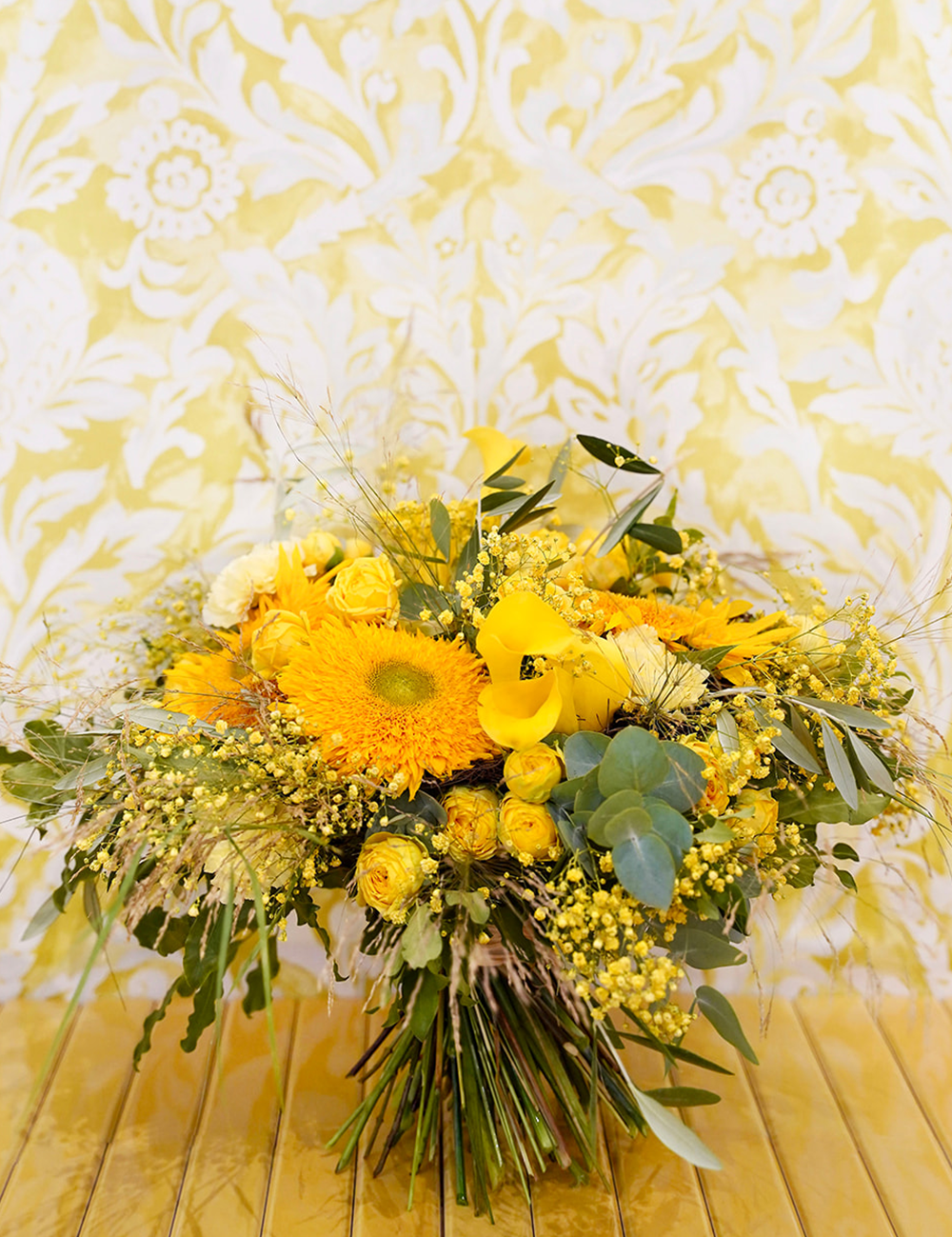Bouquet de fleurs au style champêtre et vaporeux dans les tons jaunes avec des touches de vert.