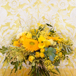 Bouquet de fleurs au style champêtre et vaporeux dans les tons jaunes avec des touches de vert.