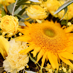 Zoom sur un bouquet de fleurs au style champêtre et vaporeux dans les tons jaunes avec des touches de vert.v