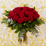 Bouquet de roses dans les tons rouges avec des touches de vert.