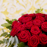 Zoom sur un bouquet de roses dans les tons rouges avec des touches de vert.